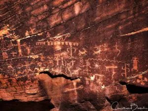 A rock with a lot of petroglyphs on it.