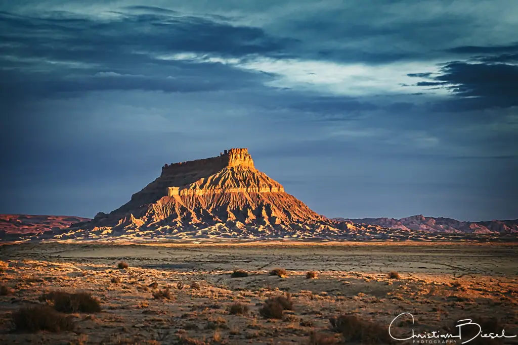 Beeindruckende Wüstenlandschaft um den Factory Butte in goldenem Sonnenlicht, perfekt für Naturliebhaber und Abenteuerfans.