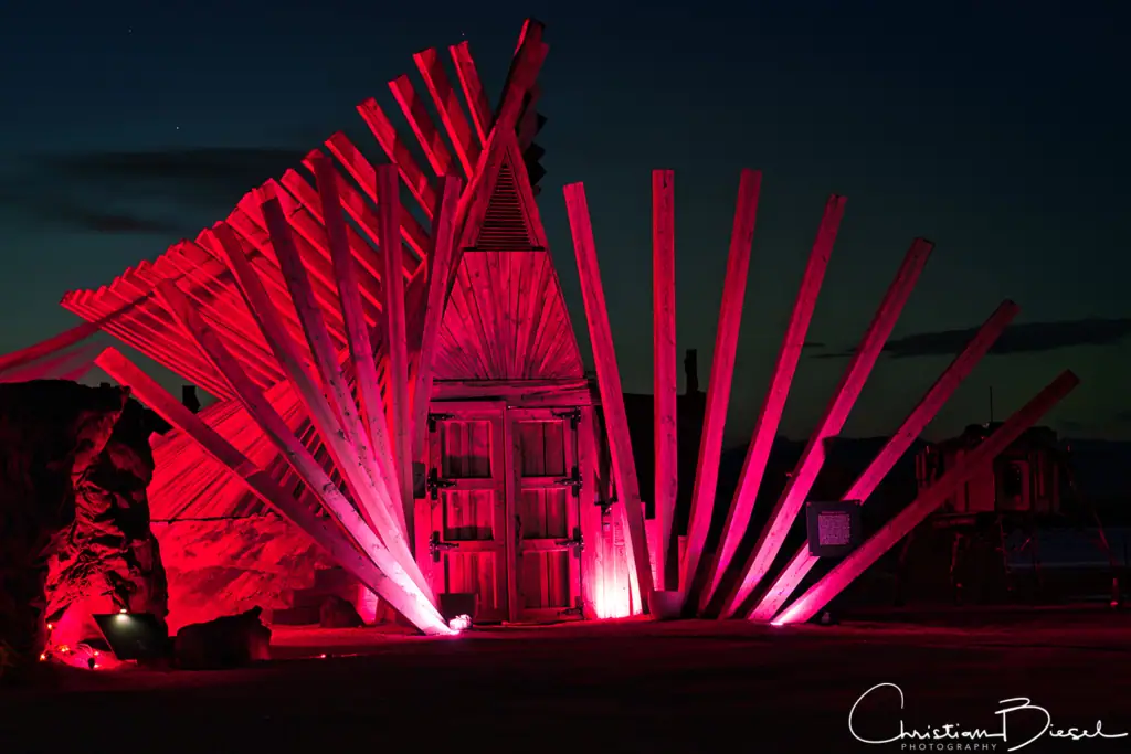 Outpost X's Kaan Lounge bei Nacht, beleuchtet in Pink, mit kreativer Architektur und künstlerischem Design.